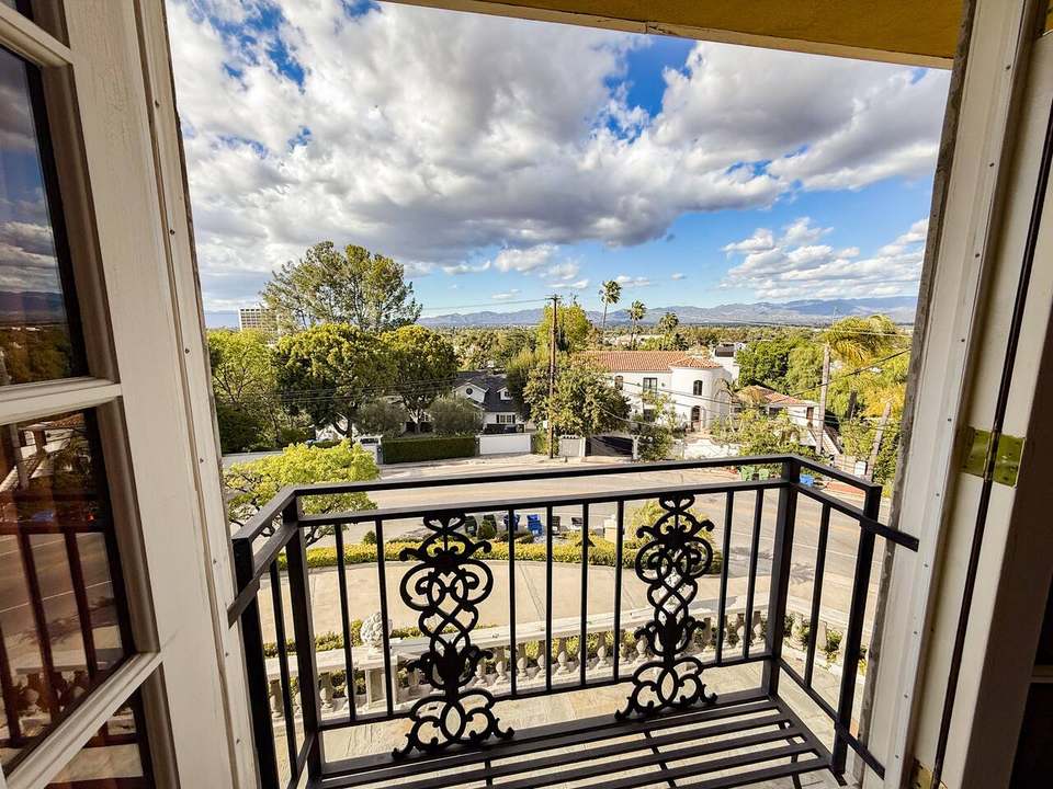 Wrought-iron Juliet balcony off the California king bedroom, looking over palms and the Valley