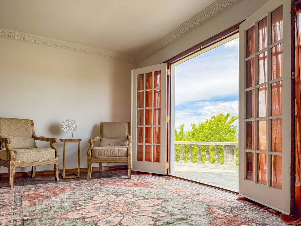 Living room sitting area with two upholstered armchairs by open French doors